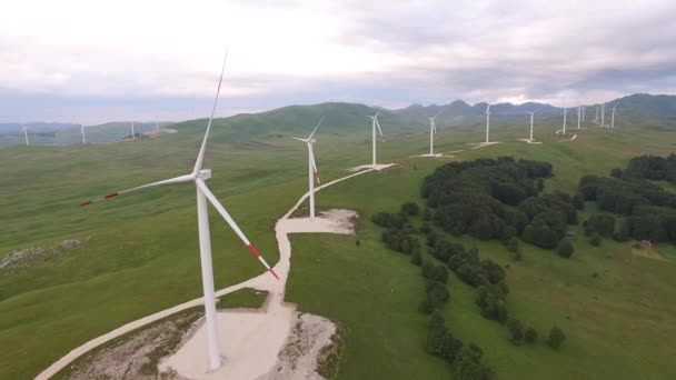 Un avión no tripulado vuela entre enormes explosiones de turbinas eólicas en un parque eólico en Montenegro . — Vídeo de stock