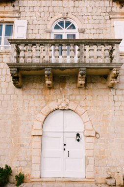 Evin girişi balkonun altındaki beyaz bir kapıdan..