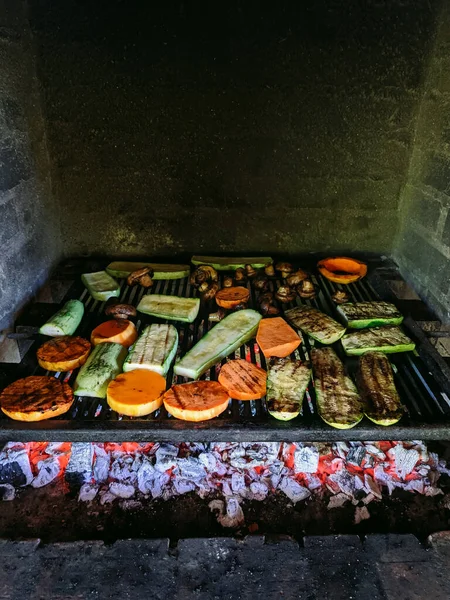 Grilled vegetables. Courgette, mushrooms and pumpkin on a metal grill over red coals. — Stock Photo, Image