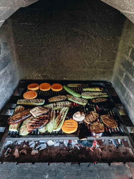 Verduras a la parrilla. Calabacín, champiñones y calabaza en una parrilla de metal sobre carbones rojos. —  Fotos de Stock