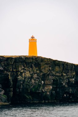 İzlanda 'da bir uçurumda kocaman turuncu bir deniz feneri..
