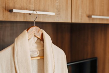 Dolabın içinde iki beyaz bornoz ve açık bir kapı ve bir televizyon deliği var..