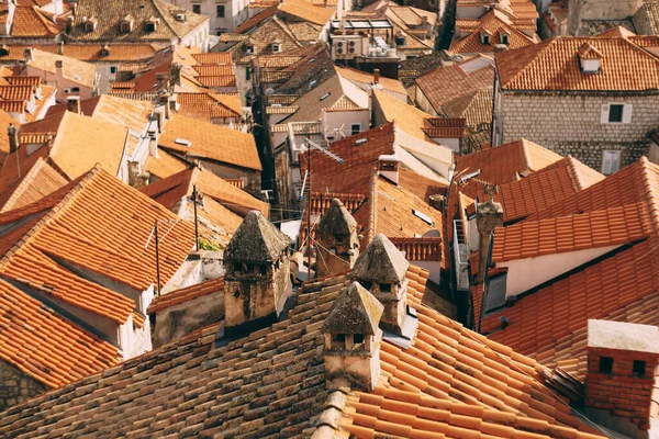 General plan of old orange roofs of houses with shabby chimneys and antennas.