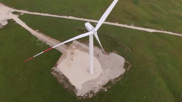 Niksic, Montenegro - 01 ottobre 2019: Primo piano delle pale delle turbine eoliche con strisce rosse contro una foresta e un campo verdi. — Video Stock