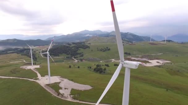 Niksic, Montenegro - 01 de octubre de 2019: Un dron vuela entre enormes explosiones de turbinas eólicas en un parque eólico en Montenegro. — Vídeo de stock