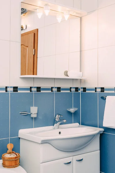 Bellagio, Itália - 07 de junho de 2020: O banheiro é azul com um lavatório, um espelho e luzes acima dele. — Fotografia de Stock