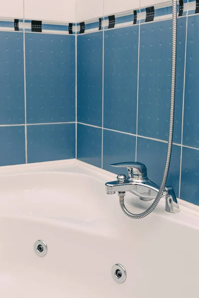 Metallbadrumsblandare med lång duschslang i blått badrum. — Stockfoto