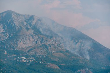 Bir orman yangınından çıkan dumanla kaplanmış Rocky dağı..