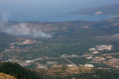 Karadağ 'da, Tivat' taki havaalanı pistinin yakınındaki Lustica yarımadasında orman yangını. Lovcen Dağı 'ndan Görünüm.