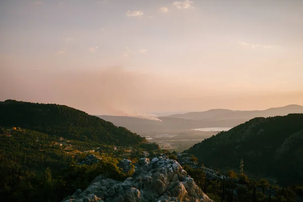 Eine Rauchsäule auf der Halbinsel Lustica in Montenegro. Waldbrände wüten bei Sonnenuntergang. — Stockfoto