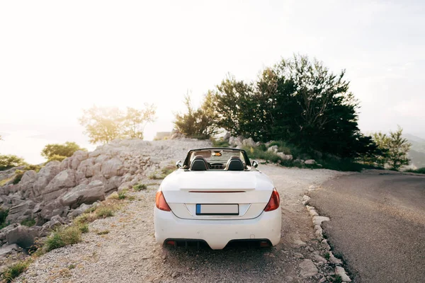 Tivat, Montenegro - 29 de julio de 2020: convertible blanco con techo abierto en el Monte Lovcen en Montenegro, al atardecer. — Foto de Stock