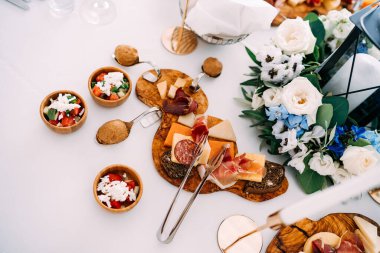 Tahtayı nefis yemeklerle, mutfak maşalarıyla ve kaşık sapıyla kesiyor. Bir şamdan fenerindeki mumla bir çiçek buketinde..