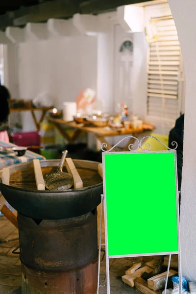 Layar hijau dengan tempat untuk memasukkan adonan terhadap latar belakang kuali dengan pilaf masak di dapur. — Stok Foto