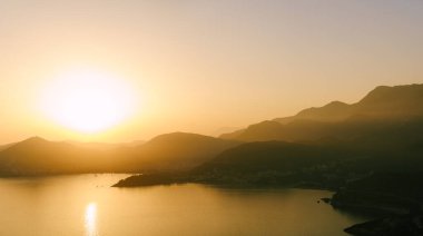 Dağların ve denizin üzerinde gün batımı, Budva, Karadağ.