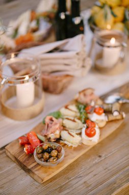 Kavanozda zeytin ve şenlik masasında mum kesmek için ahşap tahta..