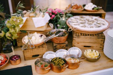 İstiridye, turşu ve güveçle dolu bir tabak. Tahta bir masanın bulanık arka planında misafirler için ikramlar..