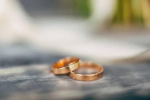 Primer plano de los anillos de boda de oro natural sobre un fondo gris. —  Fotos de Stock