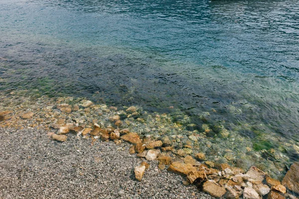 Stenen op een kiezelstrand onder water, rustig aan zee. — Stockfoto