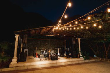 Müzisyenlerin akşamları ışıklar açıkken performansları için müzik aletleri olan bir sahne..