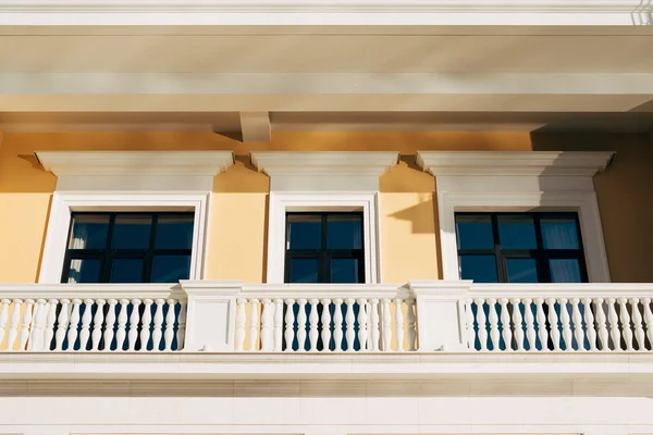 Toegang tot het balkon en de ramen in een modern gebouw met een pilaar-vormig hek. — Stockfoto