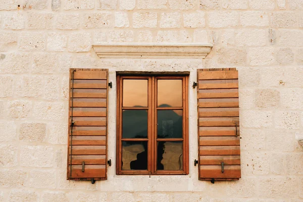 La pared de la casa es de ladrillo blanco con nuevas persianas de madera marrón y una ventana teñida. — Foto de Stock