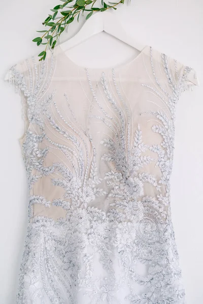 Detailní záběr na bílý korzet družičky šaty s vzory na ramínku na bílém pozadí. — Stock fotografie