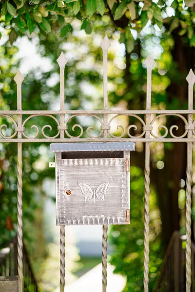 Kovová poštovní schránka s motýlím vzorem na bráně. — Stock fotografie