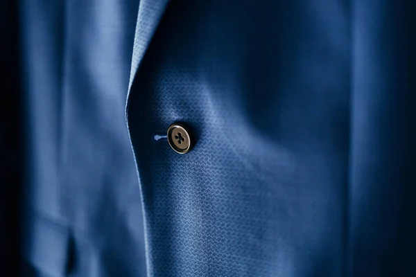 Un primer plano de un botón negro en una chaqueta para hombre azul. — Foto de Stock