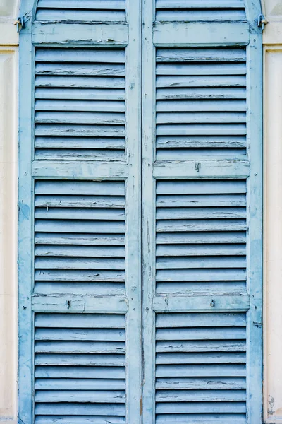 Staré modré okenice na světlé stěně domu. — Stock fotografie