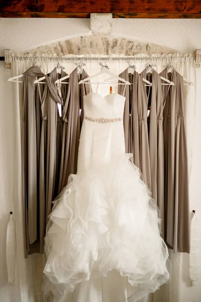 Long bridesmaid dress with a fluffy skirt on the eaves with bridesmaid dresses against the background of the window.