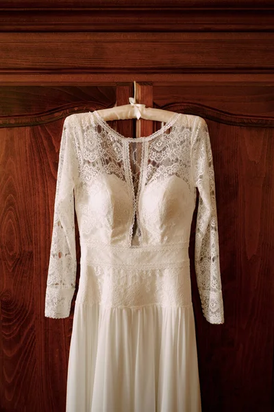 Vestido de novia con encaje en una puerta de madera marrón. —  Fotos de Stock