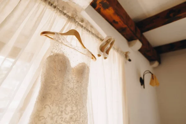 드레스를 입고 여자들은 넓은 들판의 얕은 깊이로 창문 옆의 오한에 있는 결혼용 신발을 신는다. — 스톡 사진