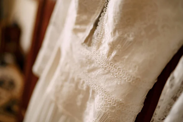 Από την εστίαση νύφες φόρεμα σε καφέ φόντο στο δωμάτιο. — Φωτογραφία Αρχείου