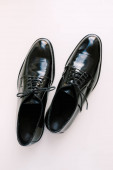 Fekete fényes férfi klasszikus derbi cipő fehér alapon.