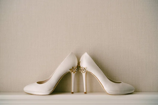 Bílé dámské boty s vysokými špičatými podpatky, se vzorem květin, na šedém pozadí. — Stock fotografie