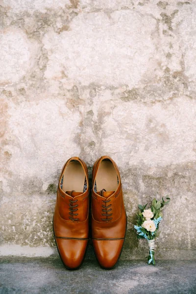 Sapatos castanhos para um homem e um noivos boutonniere. — Fotografia de Stock