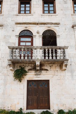 Sütunlu balkonu ve Venedik pencereleri olan antik bir bina..