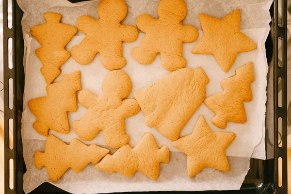 Pão de gengibre acabado de cozinhar em uma assadeira do forno, close-up de várias formas de biscoitos. — Fotografia de Stock