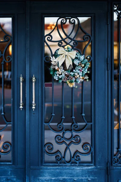 Прекрасний різдвяний вінок на дверях з кованим залізним візерунком . — стокове фото