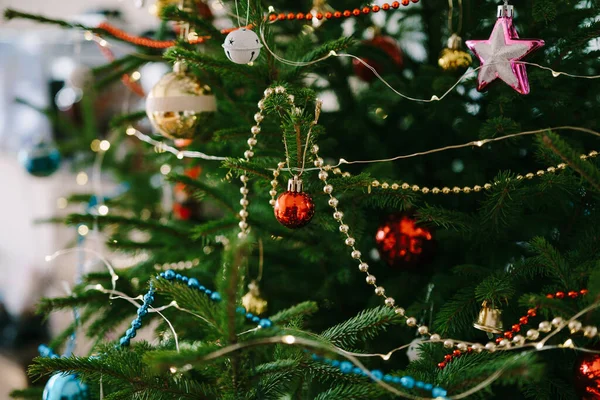 Крупним планом різдвяні прикраси, гірлянди і намистини на гілках ялинки . — стокове фото