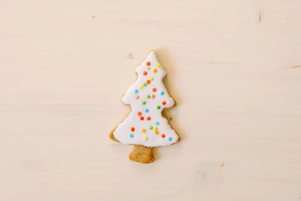 Biscoitos caseiros de gengibre na forma de uma árvore de Natal em uma textura de madeira branca. — Fotografia de Stock