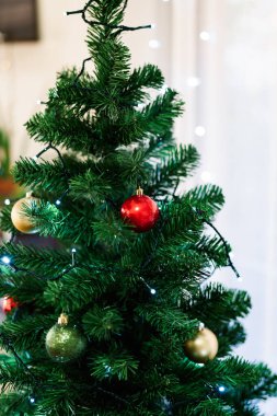 Kabarık yeşil bir Noel ağacında çok renkli Noel topları.