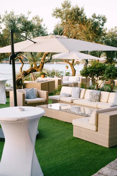 Canapés et fauteuils avec oreillers dans un restaurant près de la mer. — Photo