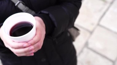 Kadın ellerinde sıcak şarap olan plastik bardak..