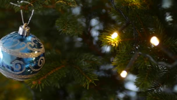 Niebieska świąteczna piłka z wzorem śniegu na gałęziach choinki. — Wideo stockowe