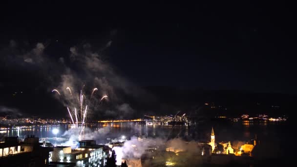 Fuegos artificiales festivos de Año Nuevo en el cielo nocturno sobre la vieja ciudad de Budva en Montenegro. — Vídeos de Stock