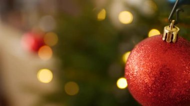 Noel ağacındaki kırmızı parıldayan topun yakın çekimi.