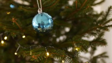 Noel ağacının dallarında parlayan mavi Noel balosu.