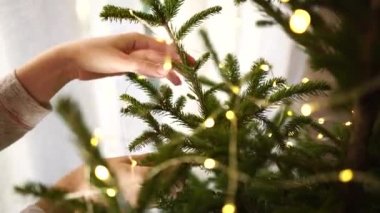 Kadınların elleri Noel ağacını süslerken birbirine yakındır..