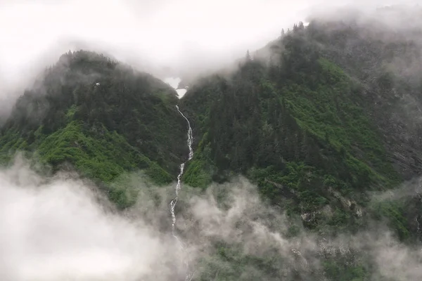 Foggy mountain range and waterfall in Juneau, Alaska